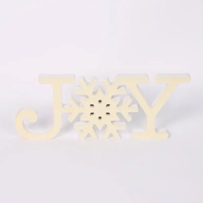 White acrylic "JOY" signage with decorative snowflake